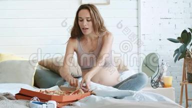 怀<strong>孕肚</strong>子坐着大披萨的肖像。 怀孕放松食物